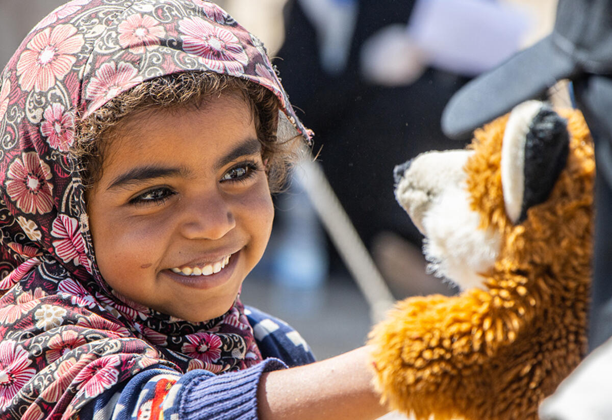 Najeeba interacts with a puppet Najeeba smiles while she reaches out to touch a fox puppet