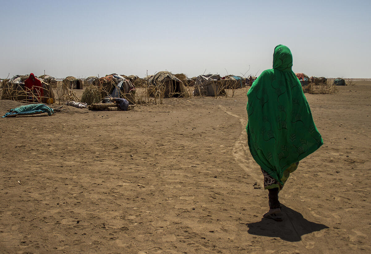 A woman looks into the distance at the temporary shelter in a refugee camp in Ethiopia. 