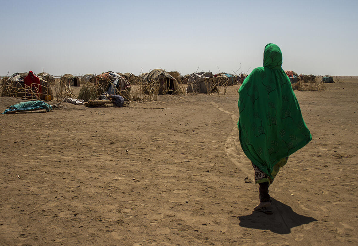 A woman looks into the distance at the temporary shelter in a refugee camp in Ethiopia. 