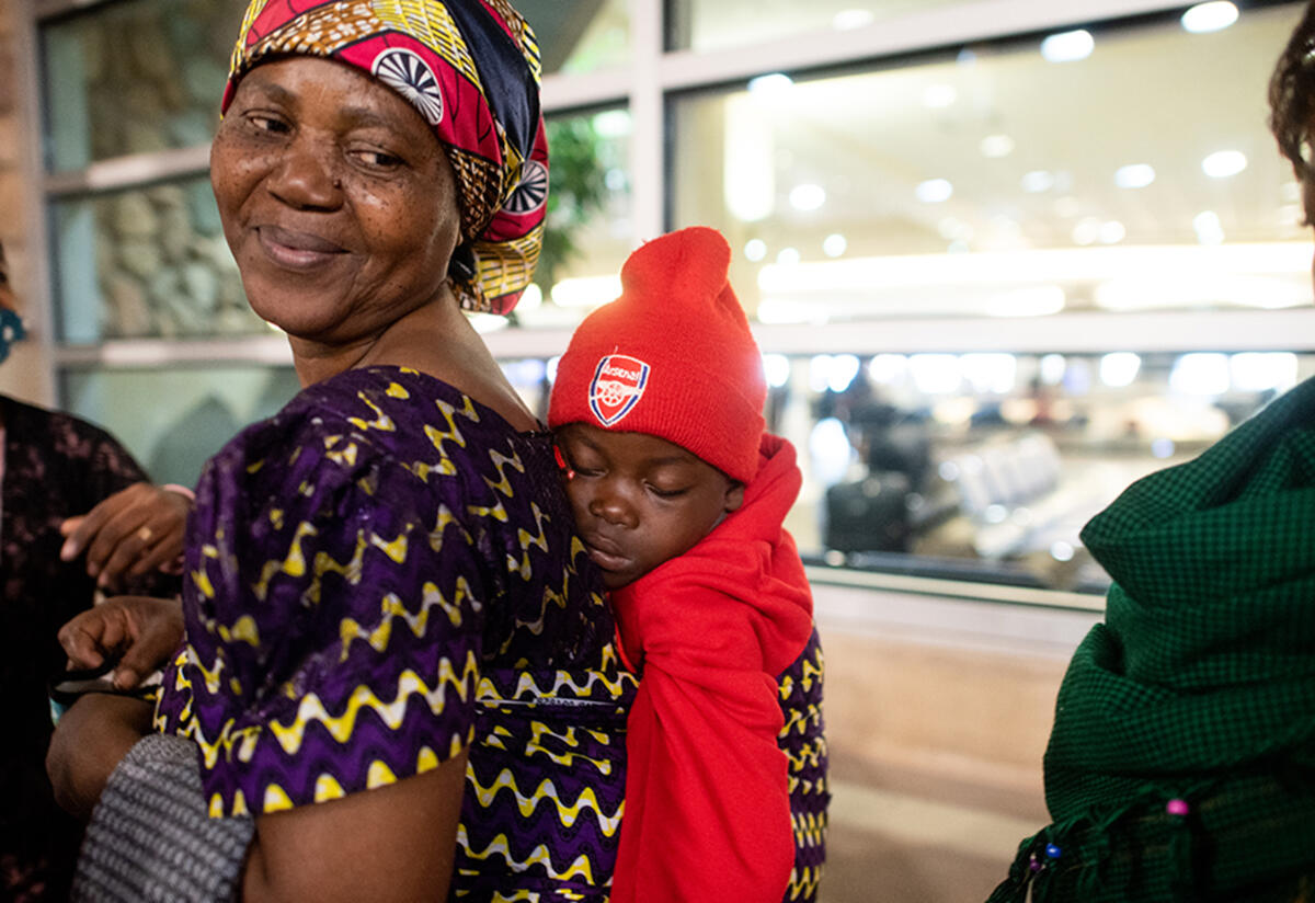 Wanyema at the airport after her daughter and grandchildren arrived Wanyema smiles with a baby on her back at the Boise Airport