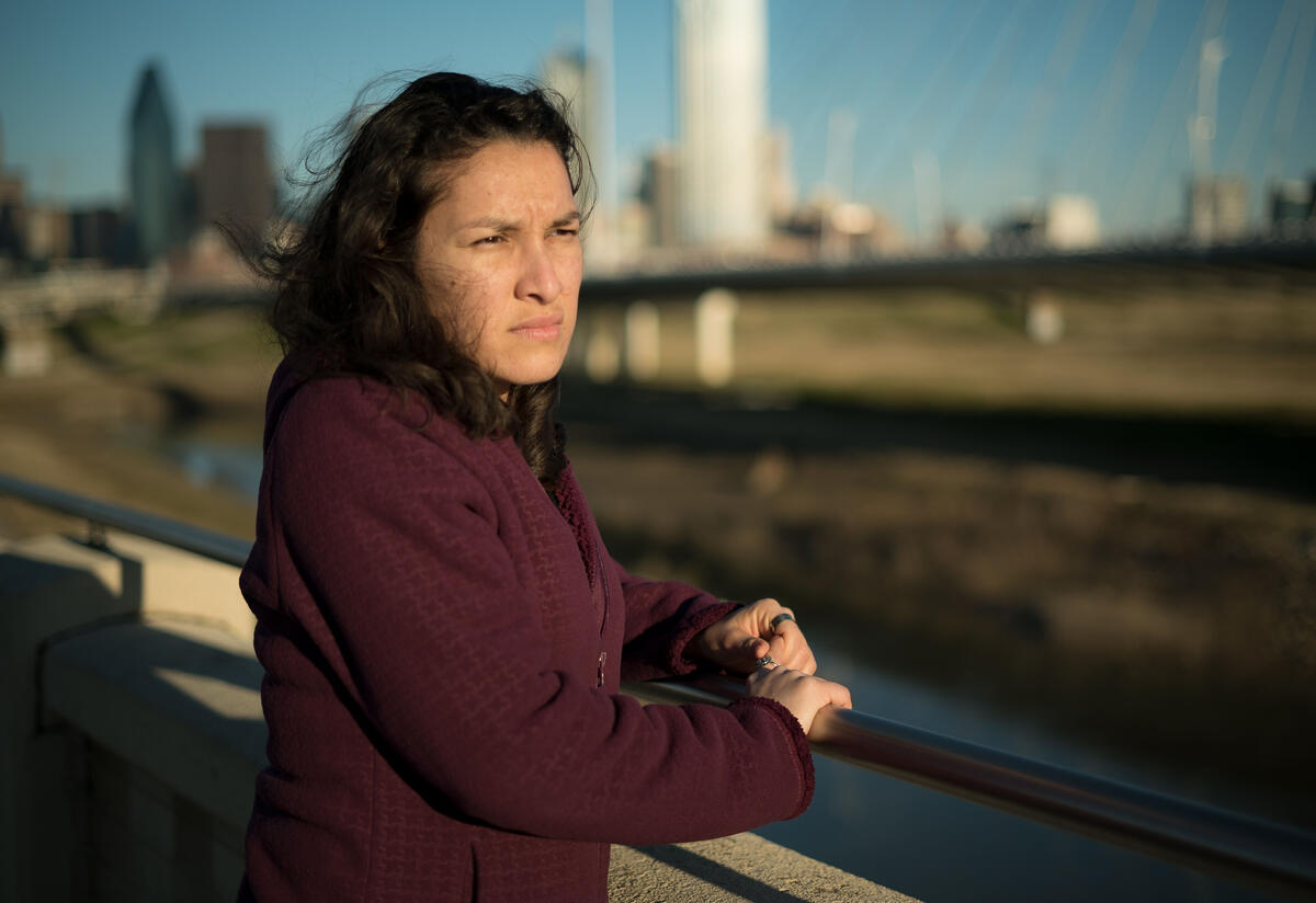 Valentina, una refugiada re-asentada en Dallas, Texas. Valentina, una refugiada de El Salvador, se encuentra en un puente en Dallas, TX, y mira hacia el agua.