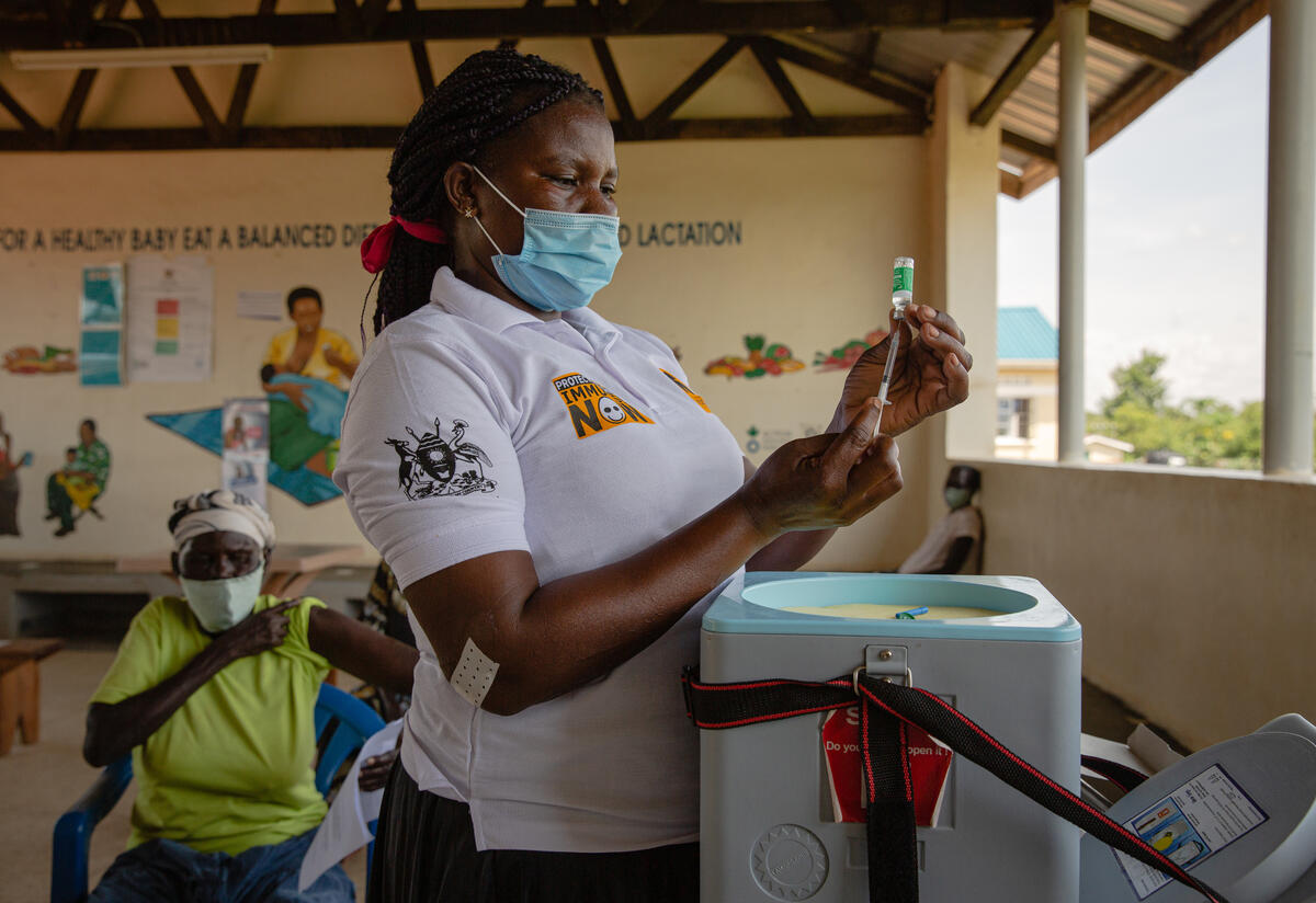 Betty Anite prepares a COVID-19 vaccination at the IRC clinic where she works in Bidi Bidi refugee settlement, in Uganda.