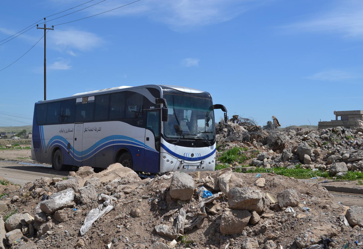 A bus carries displaced Iraqis to a screening center