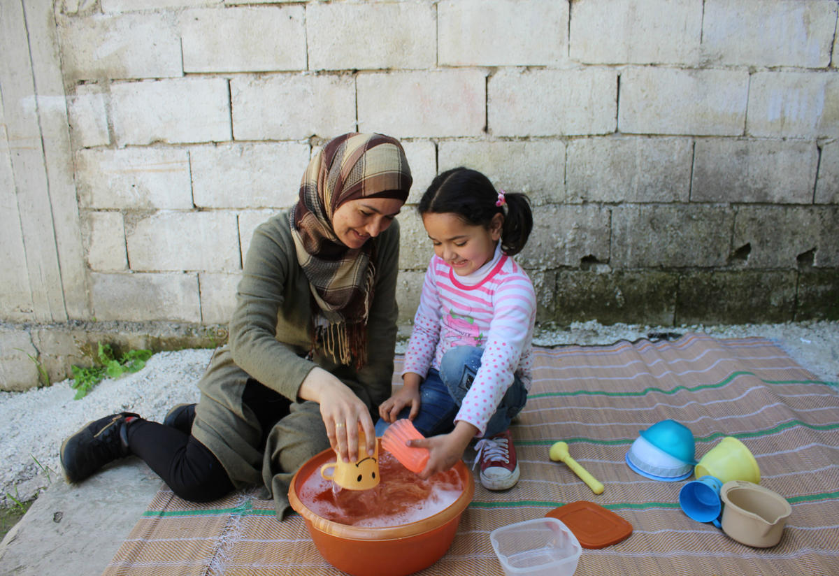 Ahlam and Sadal do an activity together while washing dishes