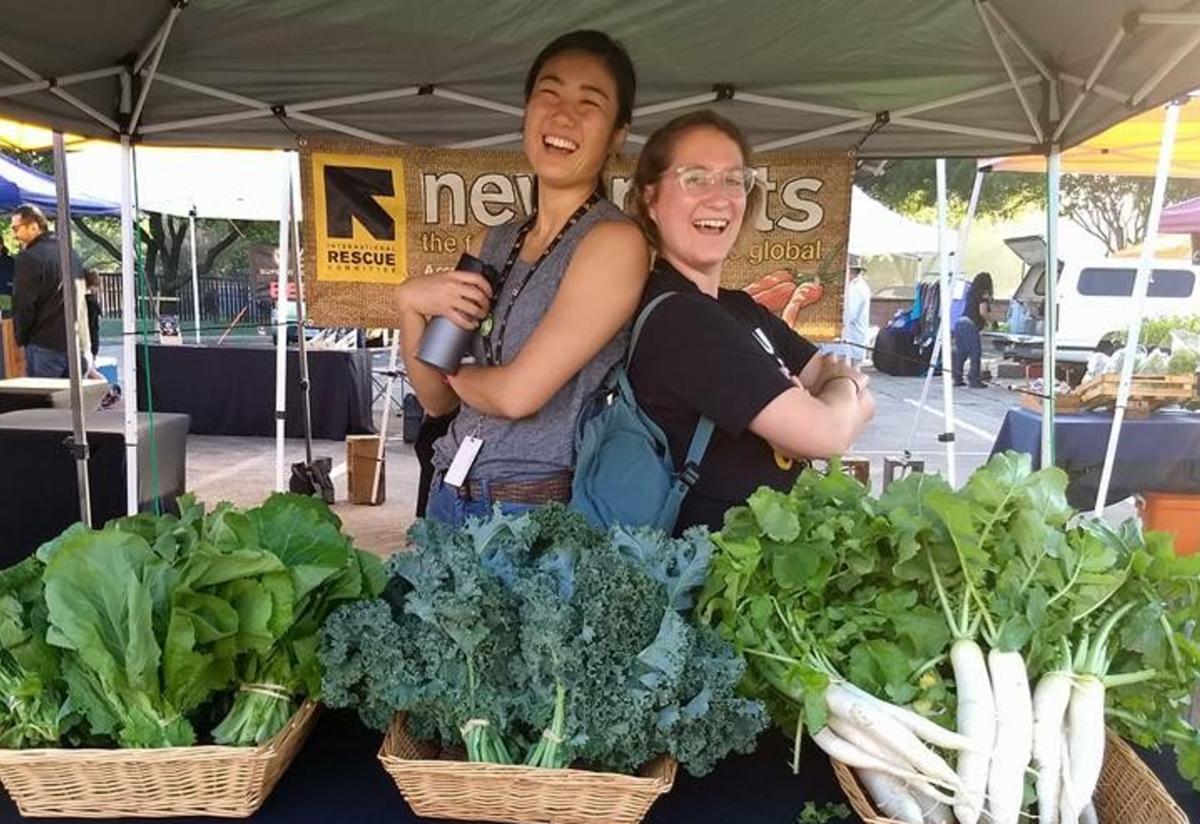 Yui Iwase and a volunteer at the farmers market with New Roots