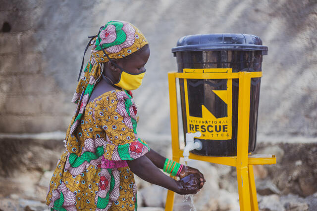 A young girl washes her hands at the IRC hand washing station