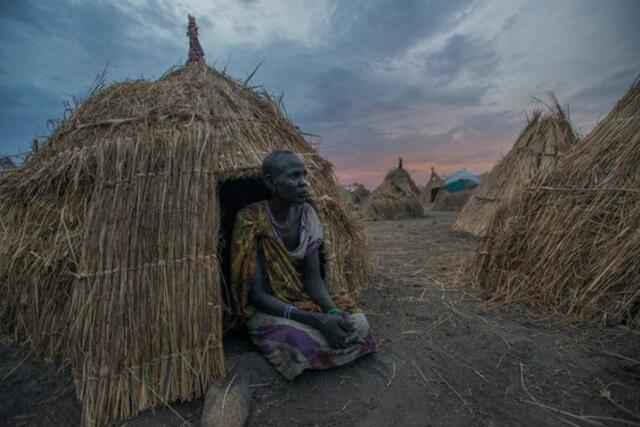 Nyanen Ruot, 65, sits in front of a makeshift shelter in a field near the town of Ganyliel. In December 2013