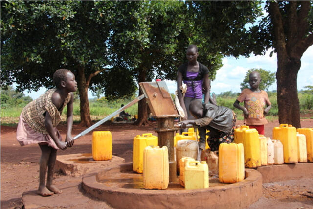 Children collect water from an IRC-installed water point in the Kiryandongo refugee camp 