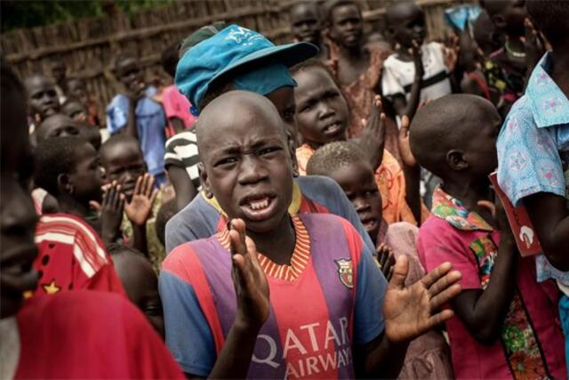 Children join in singing at a "Child Friendly Space" the IRC set up to give them refuge from the war in South Sudan