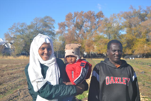 Yousef, Hawaa and their youngest son standing in a farming field in Draper, Utah.