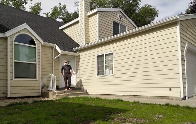 Atheer is standing in front of his house, his hands in his pockets