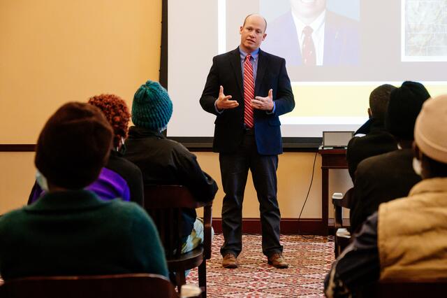 Utah State Representative Joel Ferry is presenting in a room in front of seated participants.