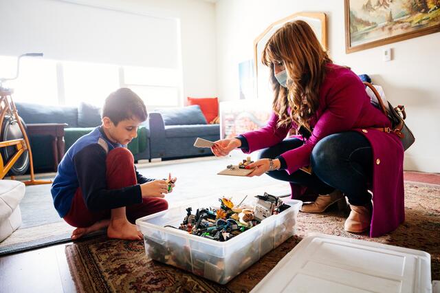 A young boy play with the Legos he received during Light One Candle with the help of his caseworker