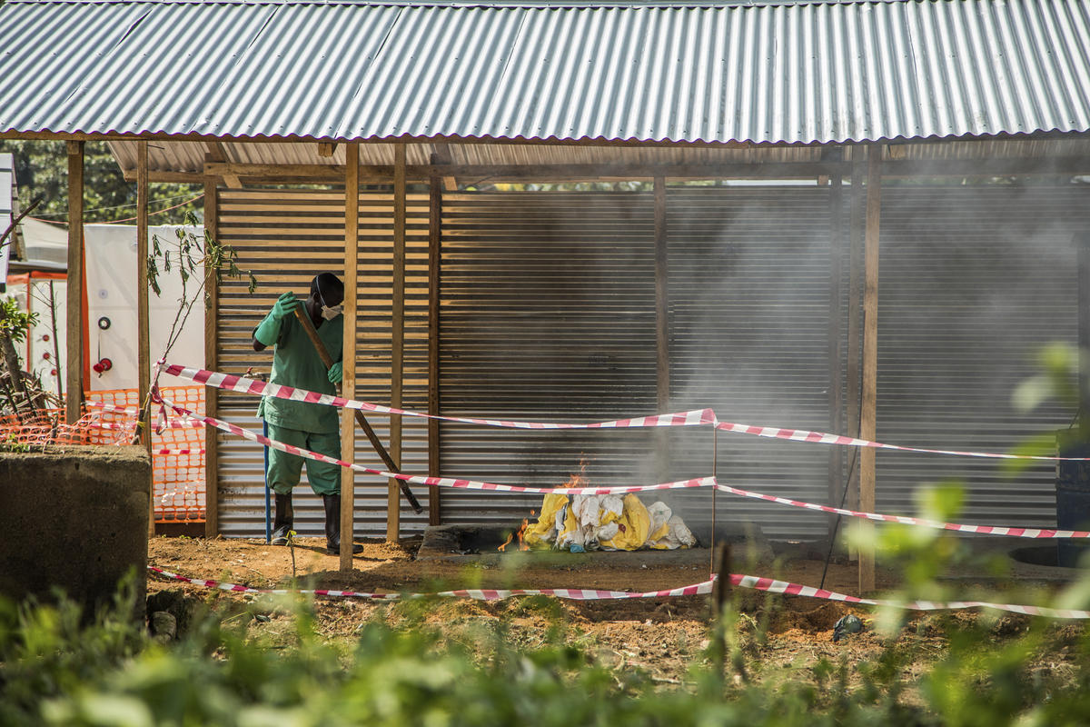 A health worker at Beni Hospital burns personal protective equipment outside the Ebola treatment center.