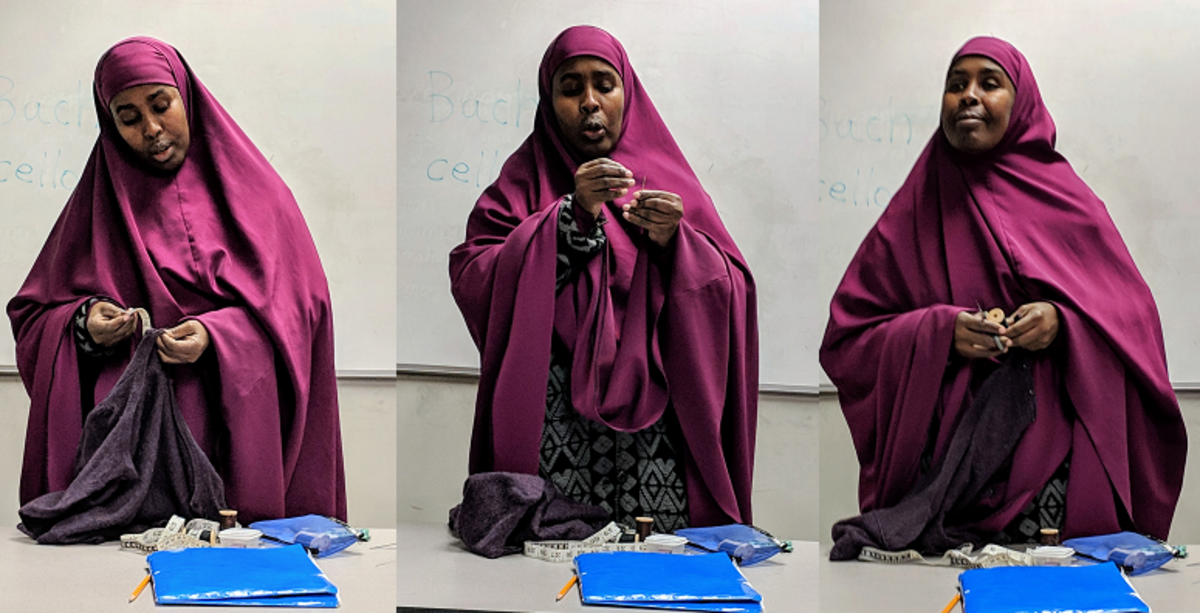 Student Hawo demonstrates how to mend torn clothing.