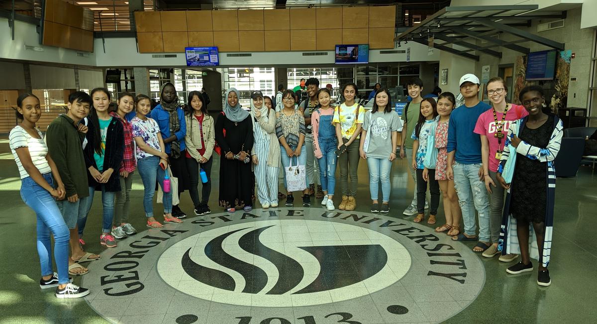 Campers traveled by MARTA to visit the Downtown GSU campus, where many plan to transfer after completing their associate degrees at the Clarkston campus. Campers and IRC staff take a group picture by the GSU sign.