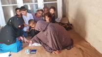 women and children sitting on the floor talking to each other