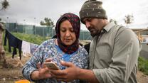 A man and a woman looking in a smartphone