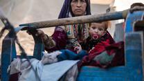 En mamma vaggar sitt sjuka barn i ett läger i det afghanska distriktet Muqur.