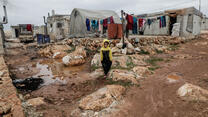 En pojke går omkring i ett flyktingläger i Idlib Syrien