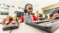 Ein Mädchen beim computer-gestützten Lernen in einem IRC-Sommerkurs