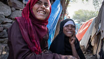 Aisha and Na'aem sitting together and smiling