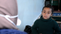 Ein syrisches Mädchen sitzt auf der Couch und lernt Achtsamkeitsübungen