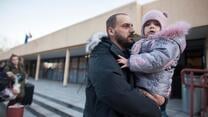 Ein Vater aus der Ukraine hält seine Tochter im Arm und ist auf der Flucht
