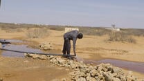 En man vid ett vattenrör i Somalia