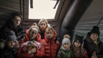 Ukrainian refugees gather in a tent at the Medyka border crossing point in Poland.