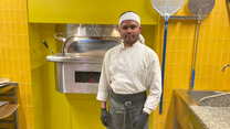 Parwan standing in front of his pizza oven
