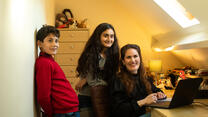 IRC client Zahra in her office with her children