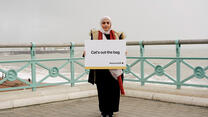 Rabab holds British Idiom sign 'Cats out the bag'