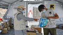 IRC volunteer Rahima talks with IRC staff member Bagcher Nazari in the IRC tent in Lesvos RIC. 