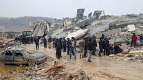 Residents observe a collapsed building.