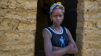 A woman poses for a portrait outside of a building.