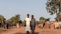 Zwei Mädchen posieren für ein Foto in Südsudan. Sie lächeln beide.