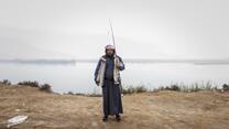 Salem*, a fisherman who recently recovered from cholera, stands by the Euphrates River. He had received full health care from the International Rescue Committee (IRC), besides awareness and education sessions for him and his family.