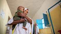 A mother holds her child close as the two walk through a malnutrition treatment ward in the Hanano Hospital in Somalia.
