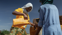 An IRC worker pouring water into a can