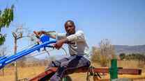 A man in Zimbabwe sits atop a piece of farming machinery.