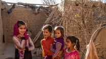 Four girls pose for a photo in an outdoors courtyard.