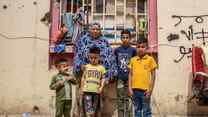 A family stands outside of a building, posing for a photo.