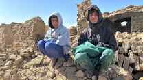 Two boys sit atop a pile of rubble from a building that was destroyed by an earthquake that struck near Herat, Afghanistan.