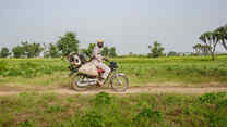 Man rides motorcycle across a green field