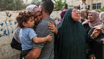 Palästinenser*innen  umarmend und trauernd abgebildet.