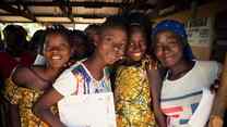 Adolescent girls attend an EAGER session in Tongo Community, Sierra Leone. A group of them pose for a photo together.
