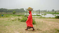 Faiza Habibu carrying bowl of fish on her head