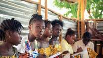 A group of girls take notes during a seminar.