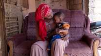 A woman with her child sitting on her lap